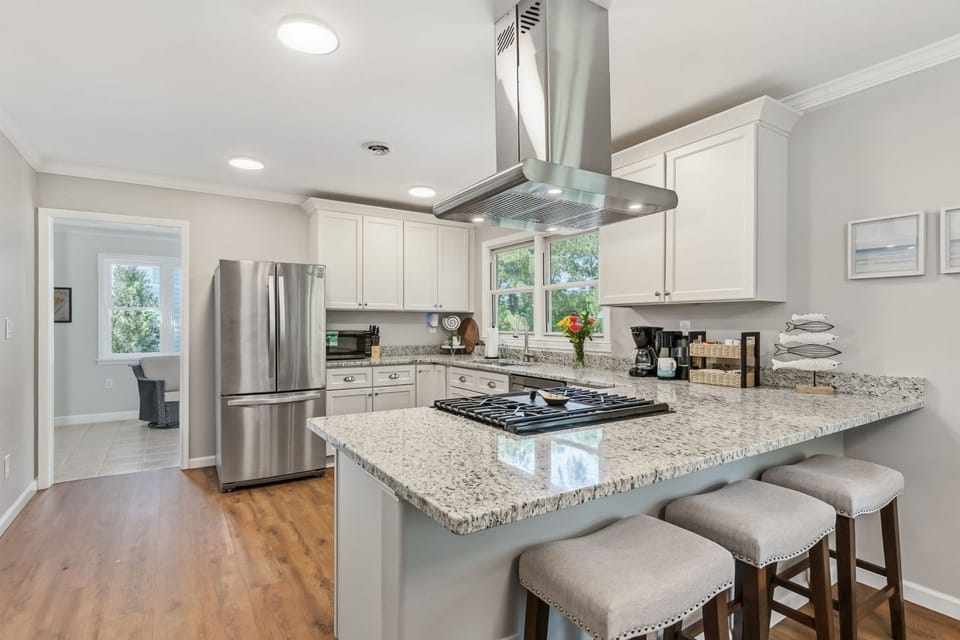Modern, updated kitchen with stainless steel appliances, granite counters, island seating, and everything you need to cook a proper meal.
