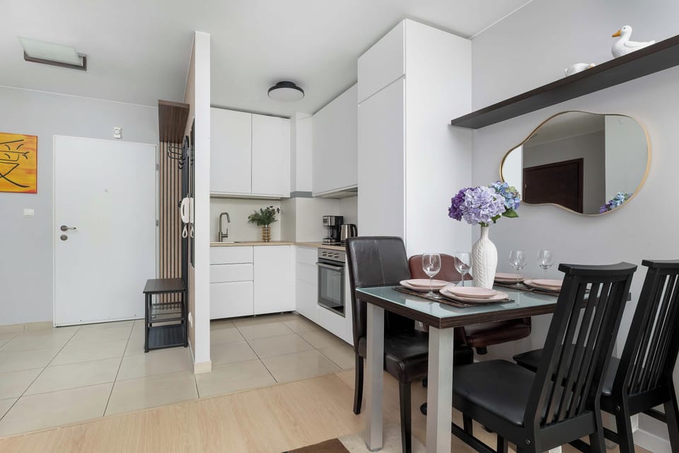 A spacious open-plan area with a dining table, kitchen, and living space arranged in a bright, modern setting.
