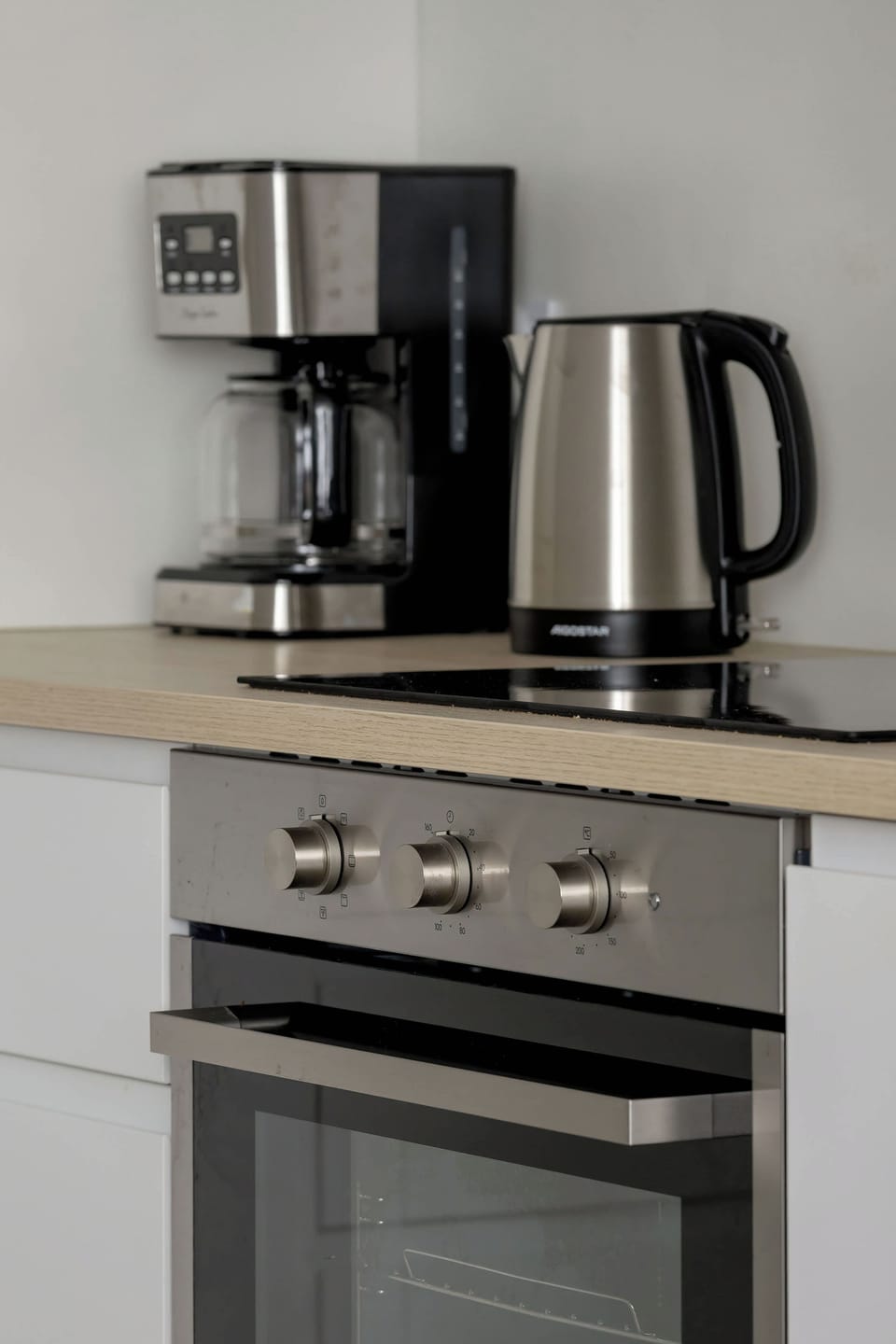 A close-up of the kitchen counter with a coffee machine, kettle, and other small appliances.