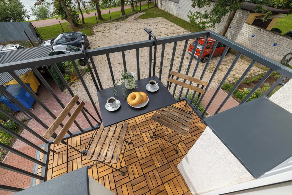 A balcony with a small table and chairs, overlooking the surrounding area.