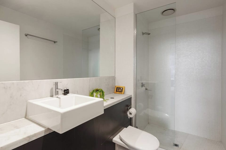 The main bathroom features a spacious walk-in shower and a large vanity space.