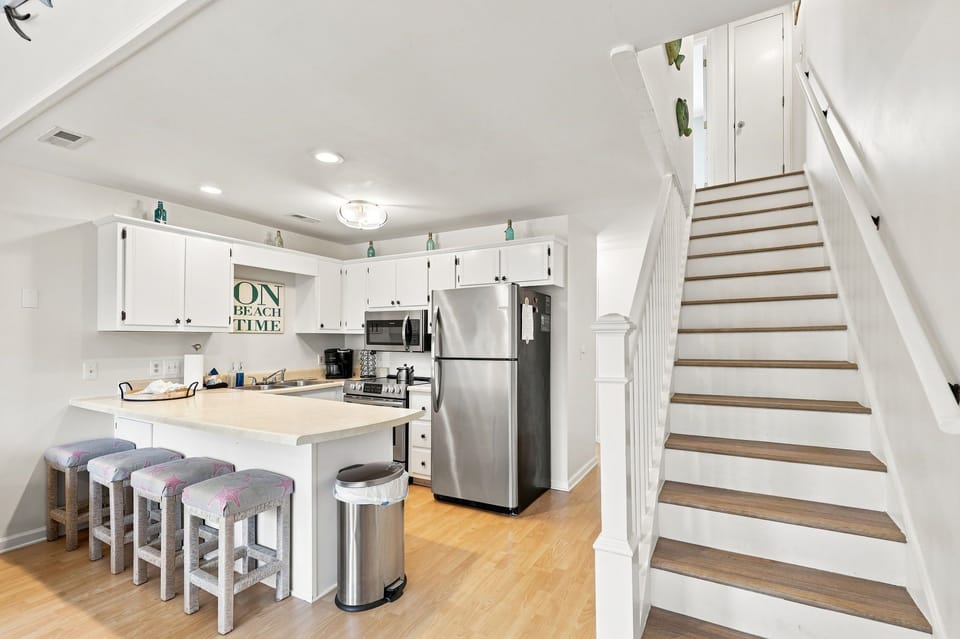 Modern stainless steel appliances meet cozy coastal touches in this fully equipped vacation kitchen.