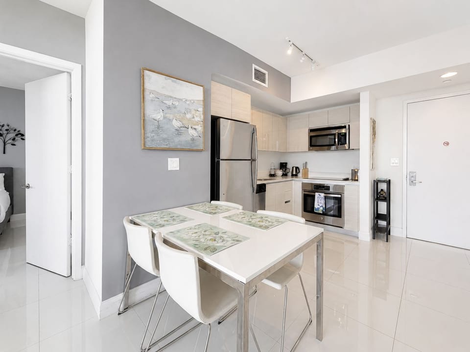 Bright modern kitchen with dining for four and sleek stainless appliances