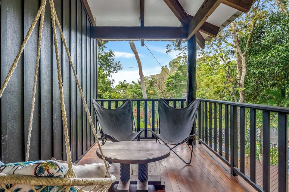 Start the day with coffee on the balcony, where comfortable seating and lush tropical greenery create a peaceful spot immersed in nature.