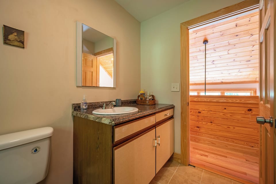 Bathroom vanity featuring a spacious wooden cabinet counter and medicine cabinet mirror.