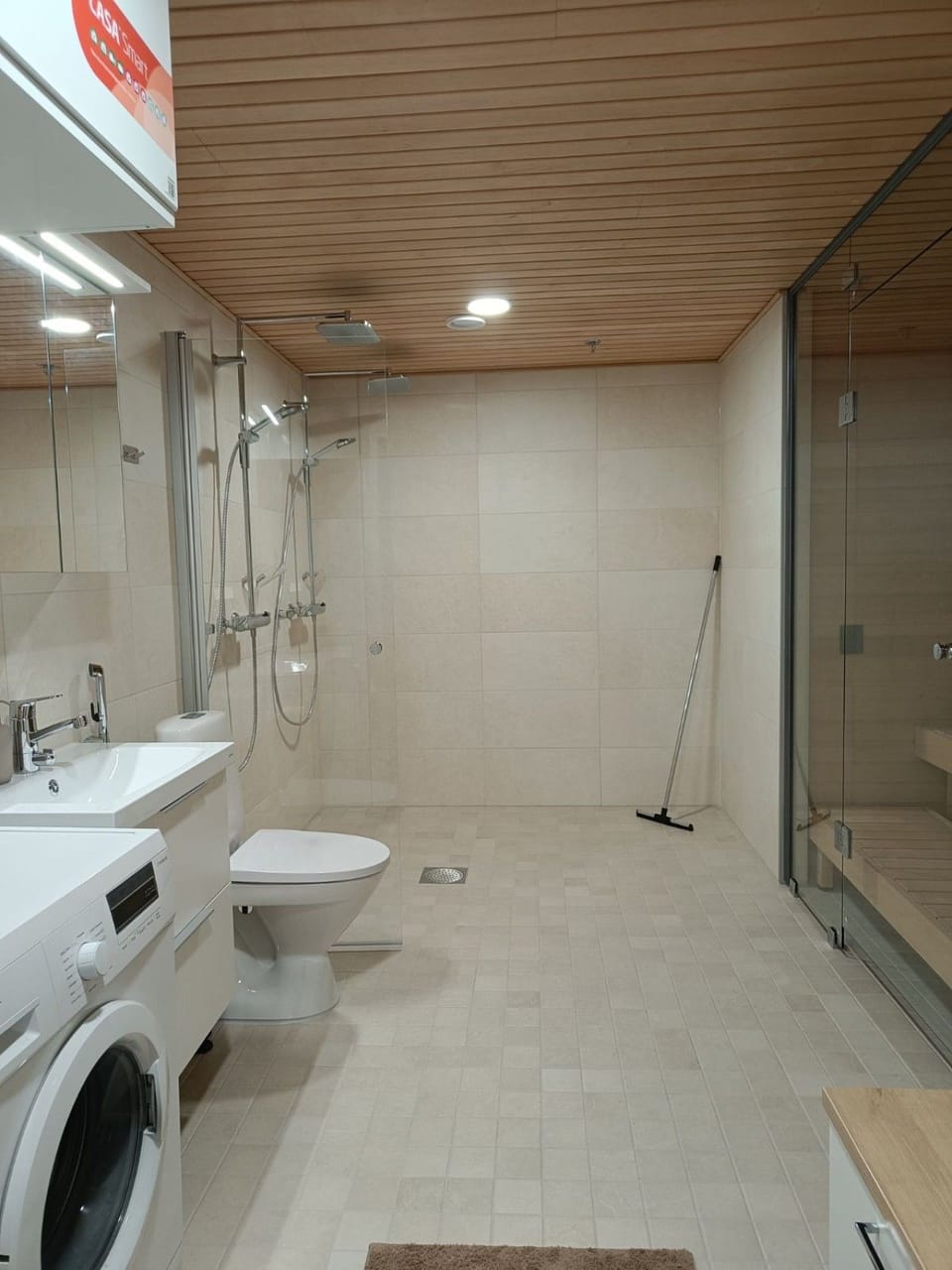 A pristine bathroom with modern showers, a private traditional sauna.