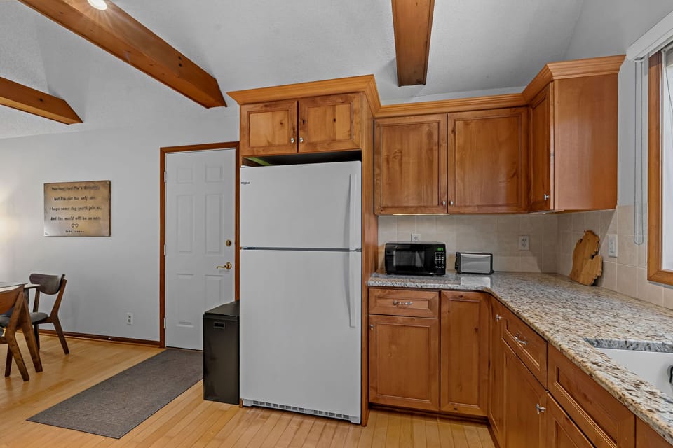 Warm wood kitchen with spacious counters and rustic beam accents