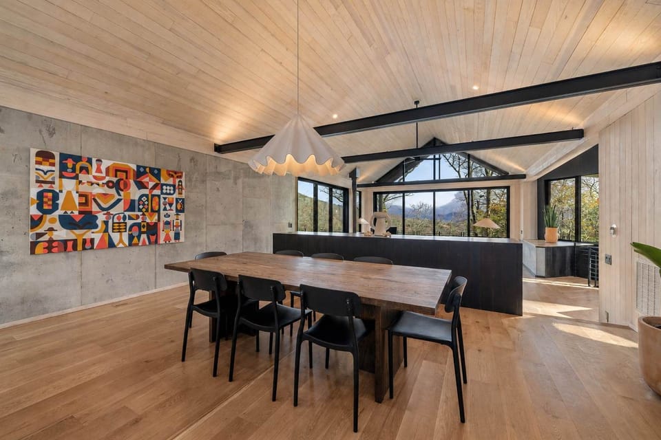 Mountain views frame the far end of the dining space, natural light and open sightlines keep the room feeling airy.