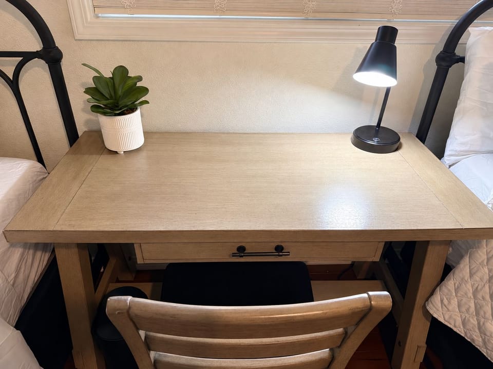 Cozy in-room workspace with desk, lamp, and thoughtful decor