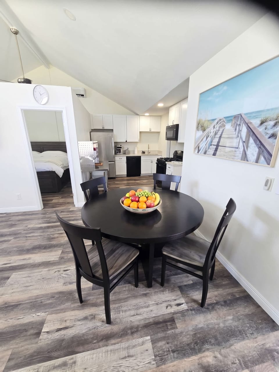 🍽️ Round dining table beneath curated coastal art—a relaxed spot to share a meal after the beach.