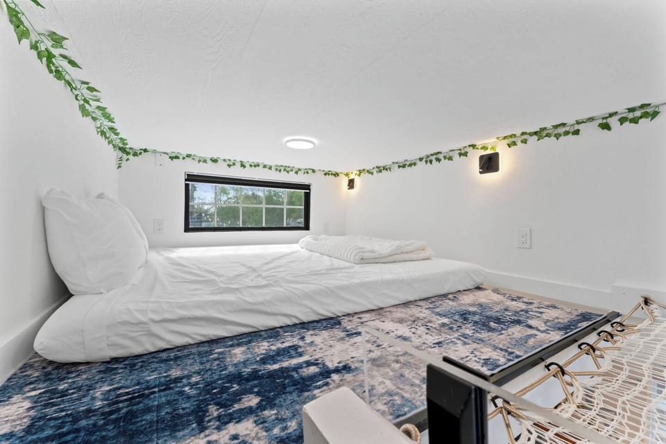Cozy loft sleeping nook with soft lighting, window views, and stylish decor