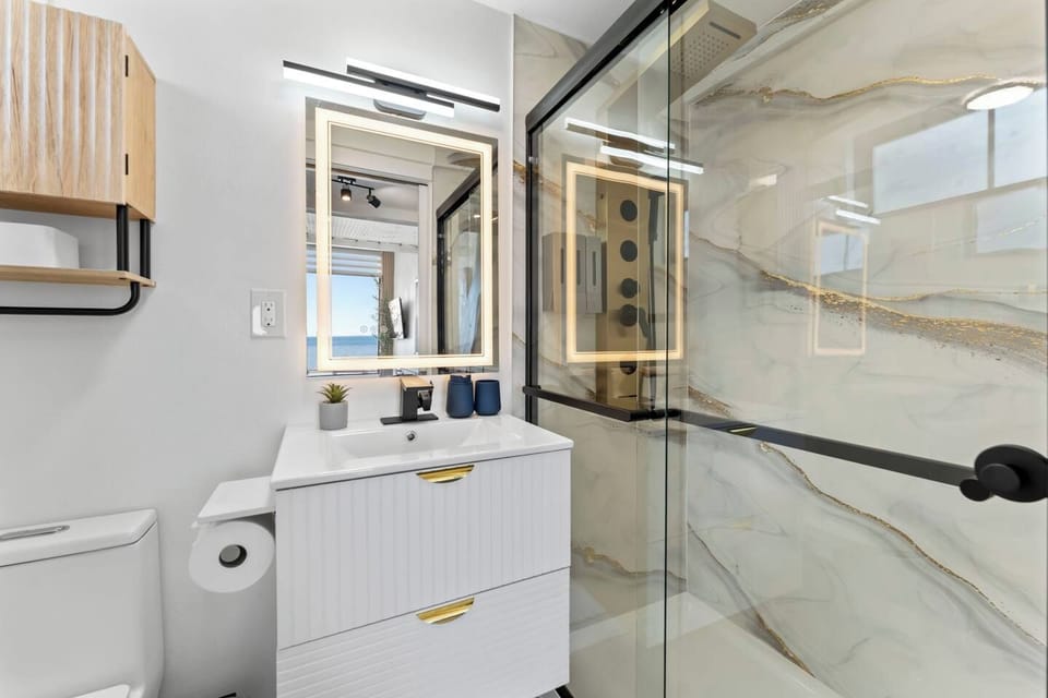 Stylish modern bath with LED mirror and luxe glass walk-in shower