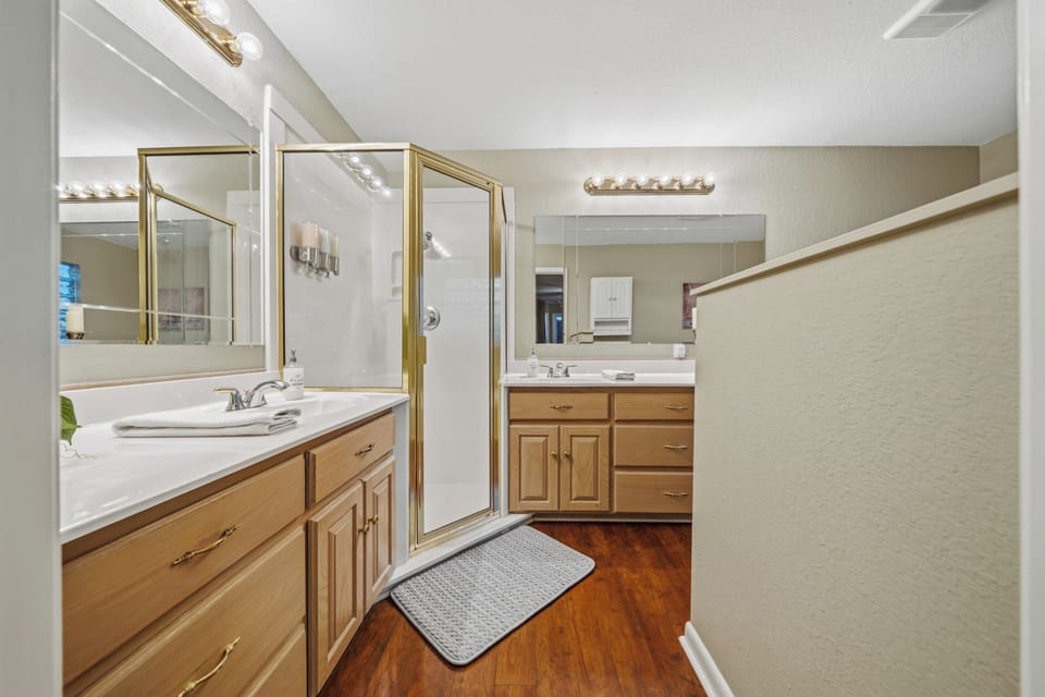 Bright, spacious bathroom with dual vanities and glass shower