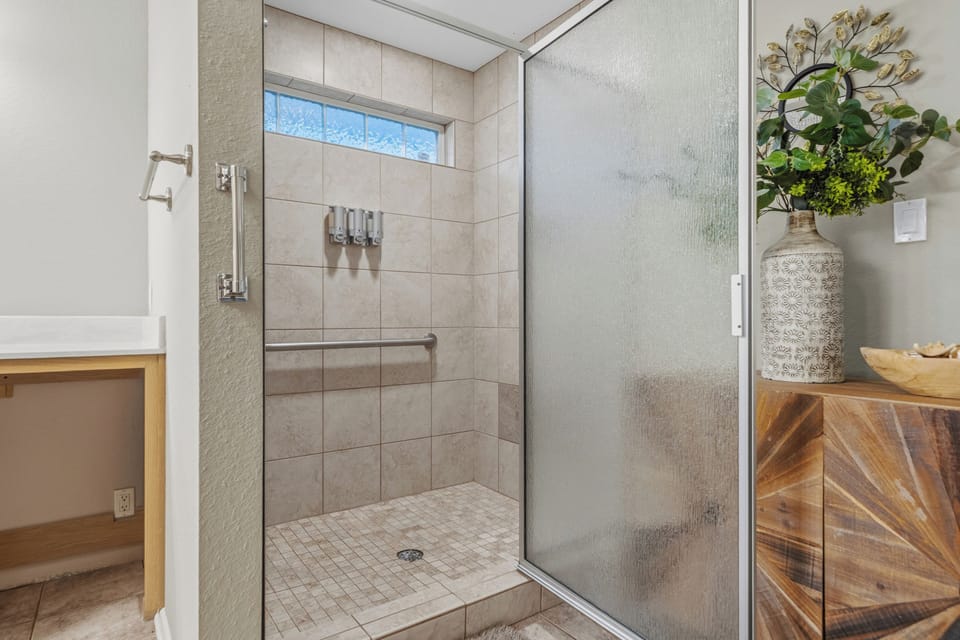Bright tiled walk-in shower with frosted glass and spa-like style