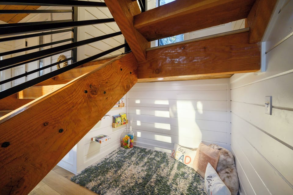 Cozy kids’ reading and play nook tucked beneath the stairs, giving younger guests their own special space to relax and have fun.