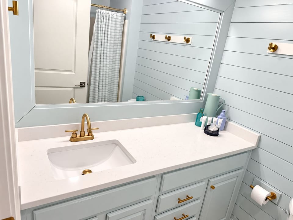 Bright, refreshed bathroom featuring a beautiful new countertop, spacious vanity, and coastal-inspired finishes.