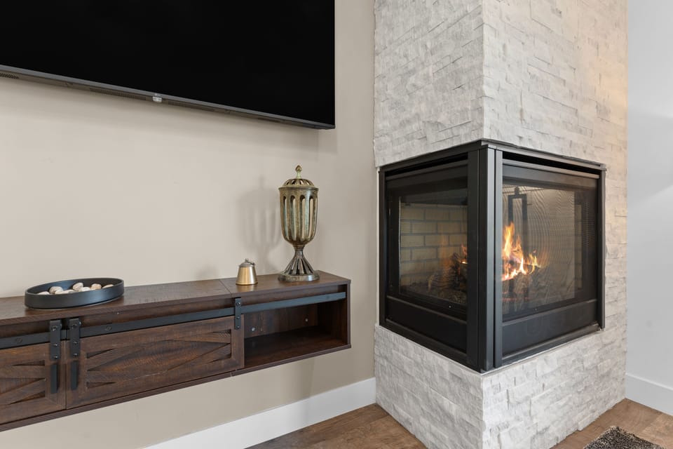 Curl up on your comfortable couch and enjoy the warmth of your own fireplace. The sleek stone surround and modern media console create a cozy yet contemporary retreat perfect for relaxing evenings.