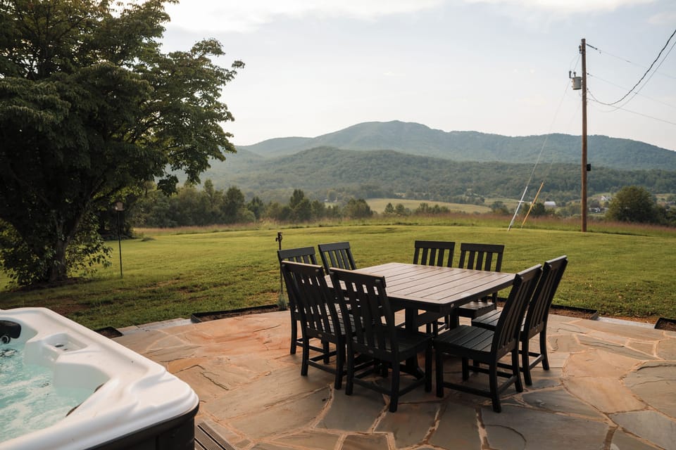 Stone patio with outdoor dining beside the hot tub