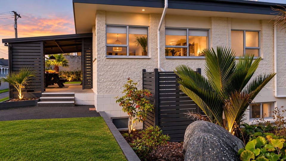 Modern home exterior with lush landscaping and inviting evening ambiance
