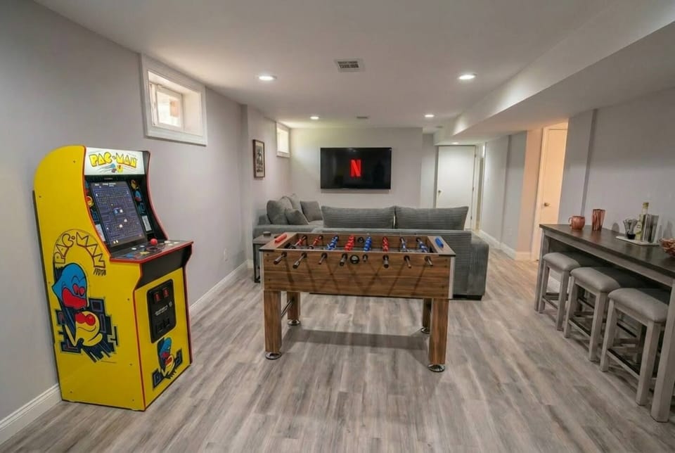 Basement game room with foosball, Pac-Man arcade, TV lounge & bar seating
