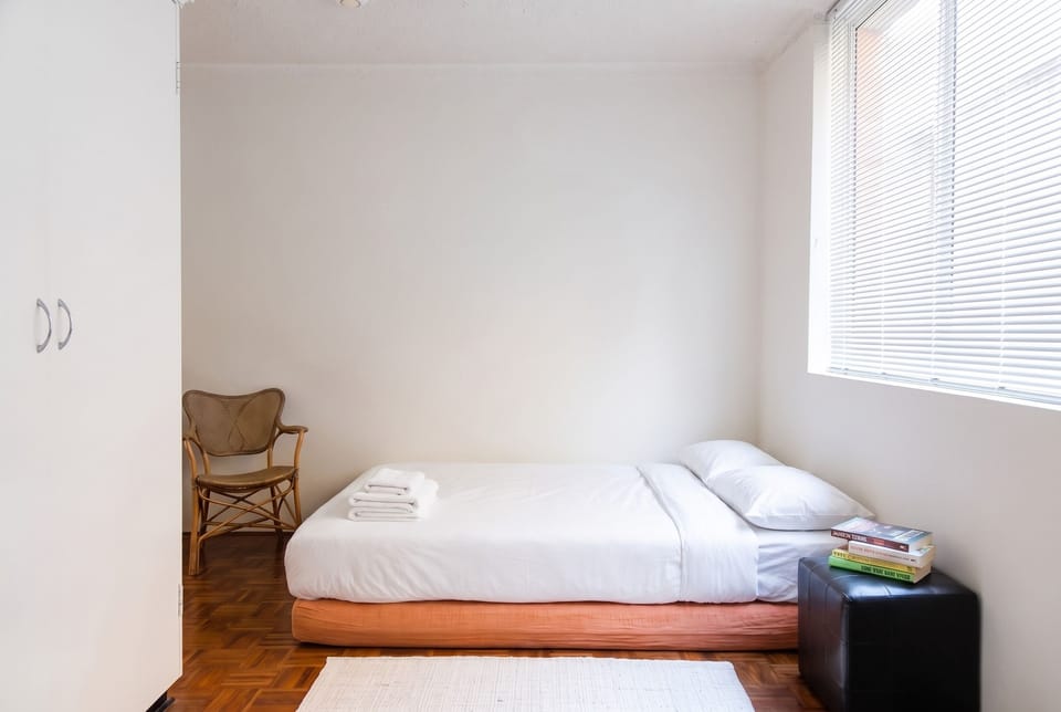 Sofa bed made up flat as a second bed with white linen