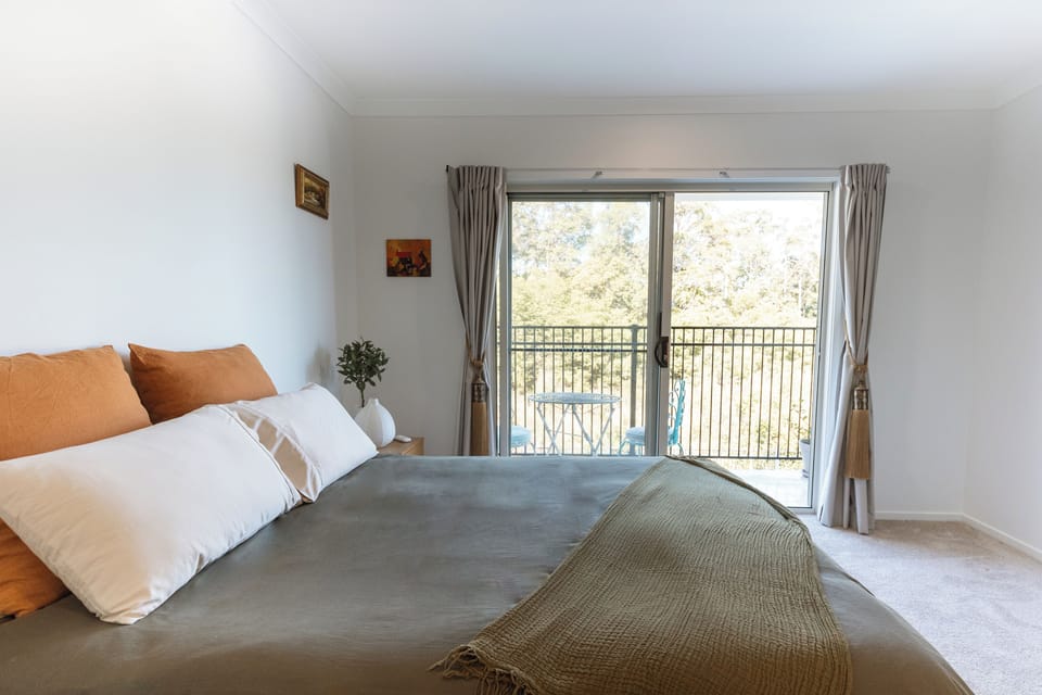 Bright bedroom with private balcony and peaceful treetop views