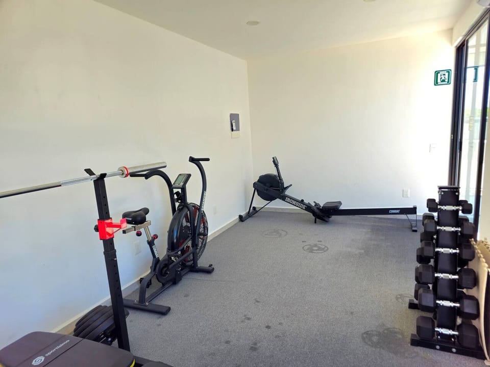 Fitness room with exercise bikes, weights and strength-training equipment.