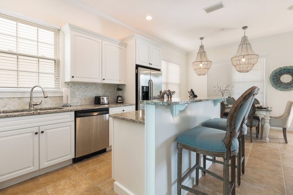 A fully equipped kitchen with stainless steel appliances and breakfast bar
