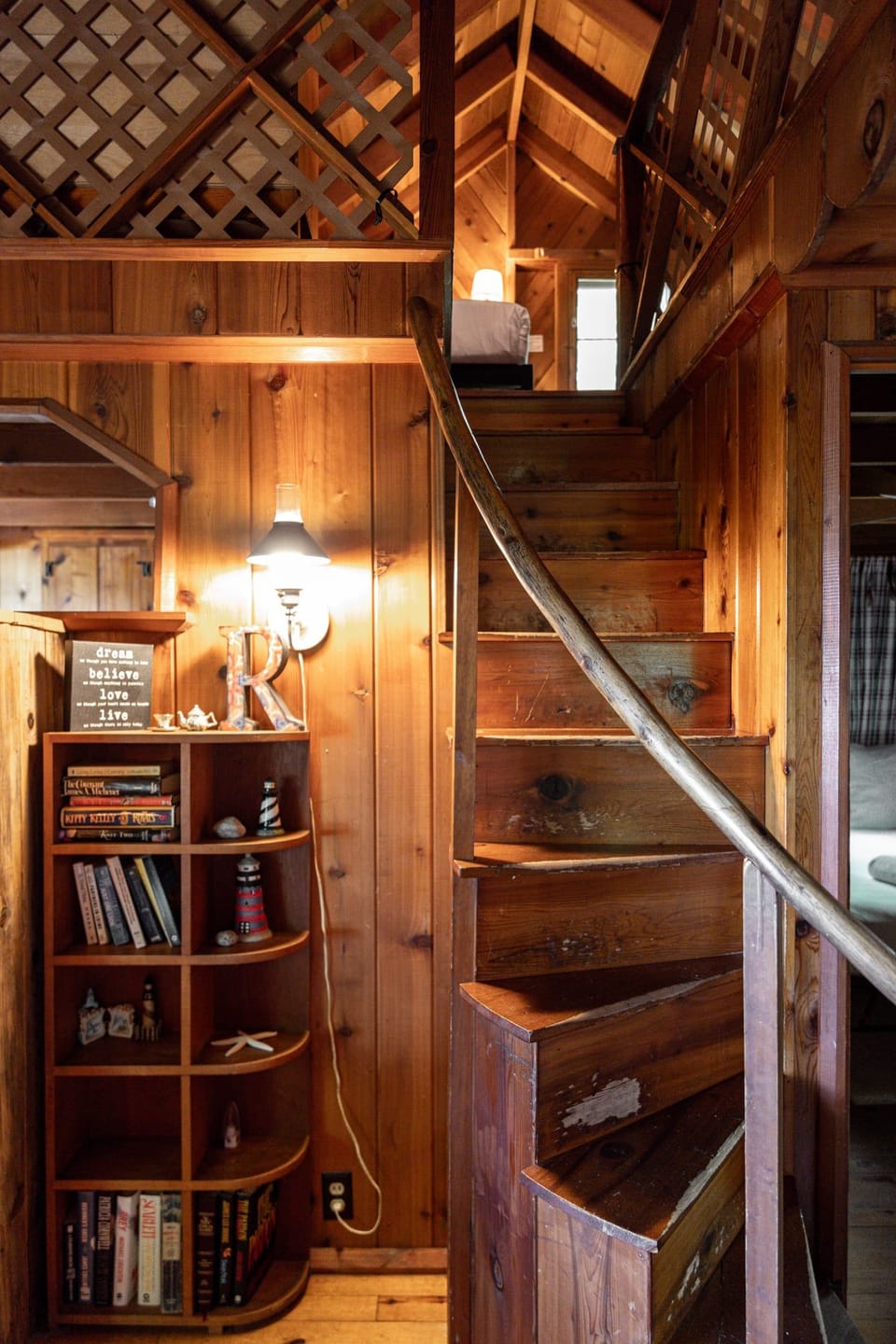 Cozy wood-paneled bedroom with fresh linens and charming vintage touches.