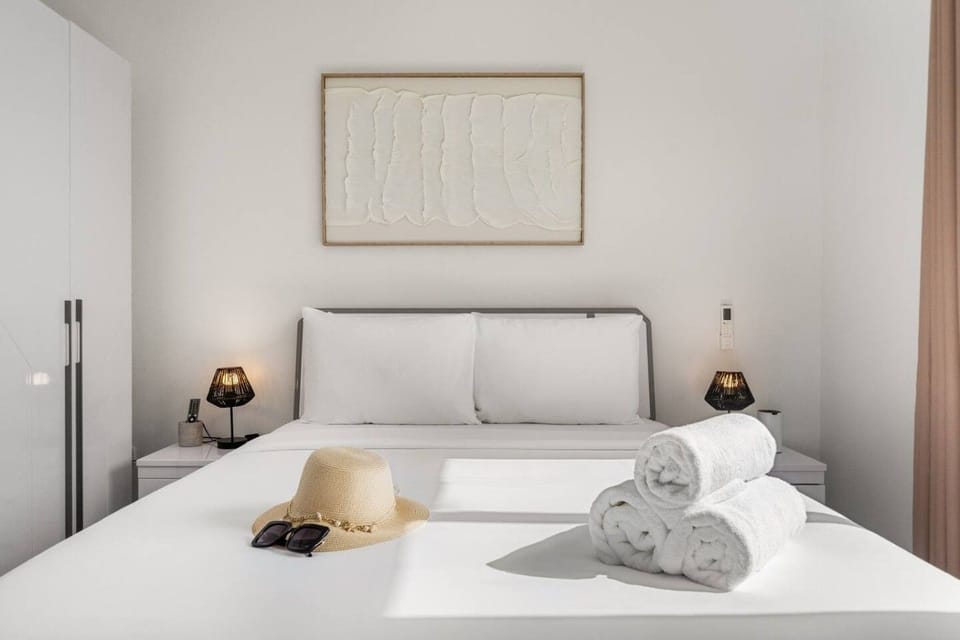 Settle into a stylish bedroom with plush linens and soft ambient lighting, creating a comfortable, beach-ready setting for your stay