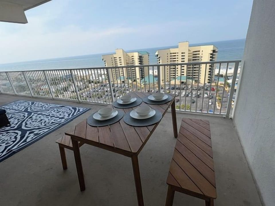 Spacious ocean-view balcony with outdoor dining and coastal high-rise views