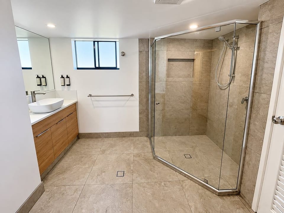 A spacious, beautifully renovated bathroom featuring a large walk-in shower, modern vanity and plenty of room to get ready.