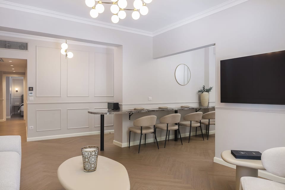 The kitchen includes a mini fridge, electric stovetop, Nespresso machine, kettle, and milk frother, along with a dining island for four—perfect for easy breakfasts or casual meals at home.