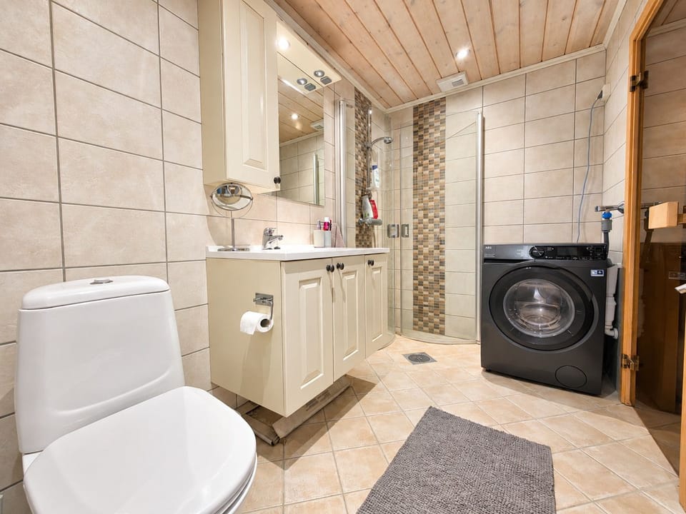 Modern bathroom with private sauna and washing machine