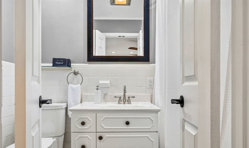Fresh white finishes and a roomy vanity keep this bathroom feeling bright and functional, with plenty of counter space for getting ready.