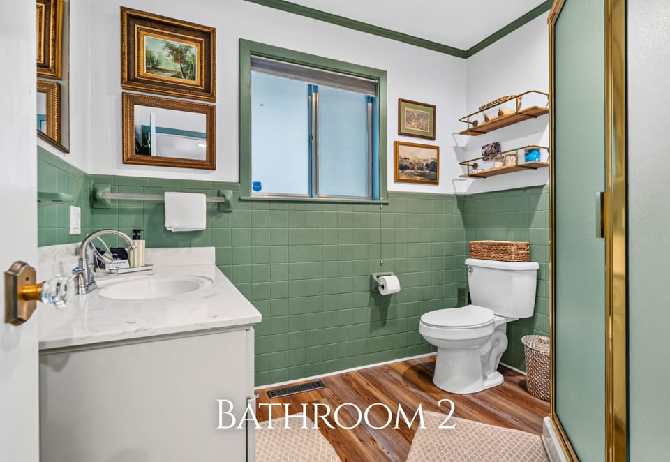 A charming mix of green and white gives this bathroom a little extra character while still offering all the essentials for getting ready each day.