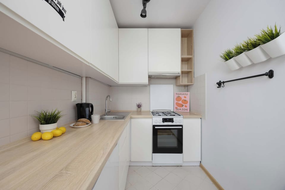 A well-equipped kitchenette with white cabinets, a countertop, stovetop, oven, and small appliances. The practical layout provides everything needed for preparing meals during your stay.