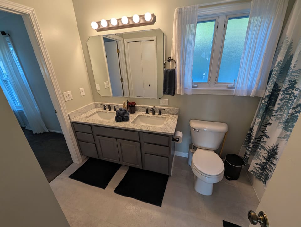 Bright full bath with double vanity, natural light, and modern finishes
