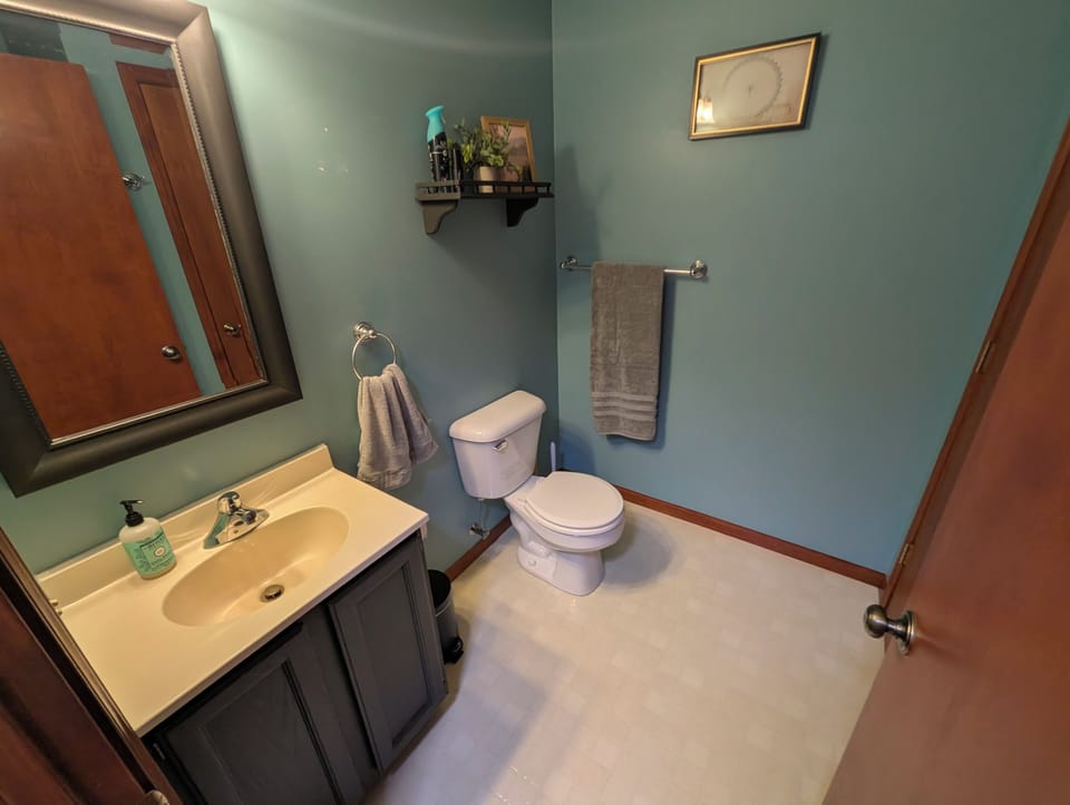 Bright, clean bathroom with vanity, large mirror, and calming blue walls