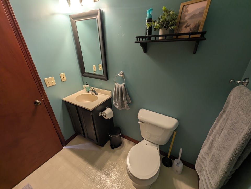 Bright, stylish half bath with fresh decor and convenient vanity sink