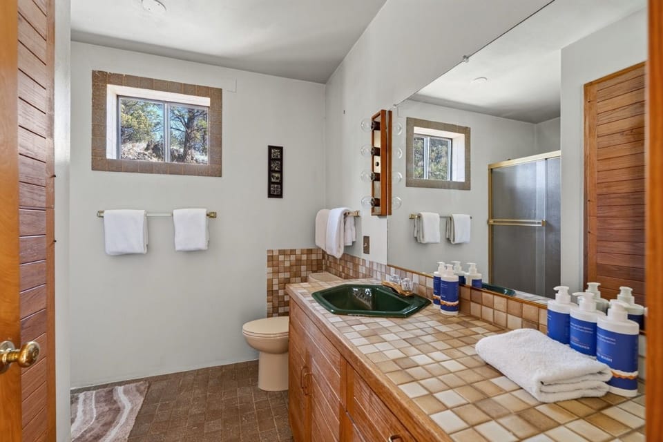 Refresh in your private bathroom with a unique green sink, mosaic tile countertops, and soft towels laid out for you—ready whenever you need them.