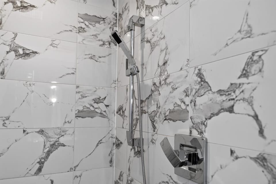 Modern marble-tile shower with sleek chrome fixtures