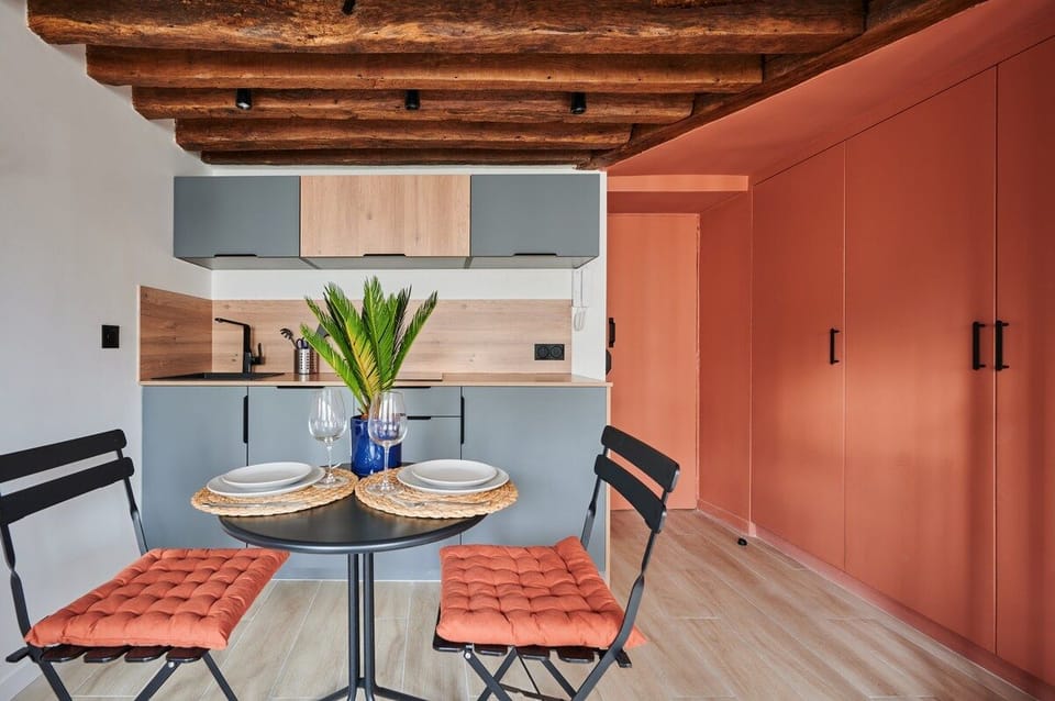 Pièce à vivre avec canapé et cuisine américaine et coin repas