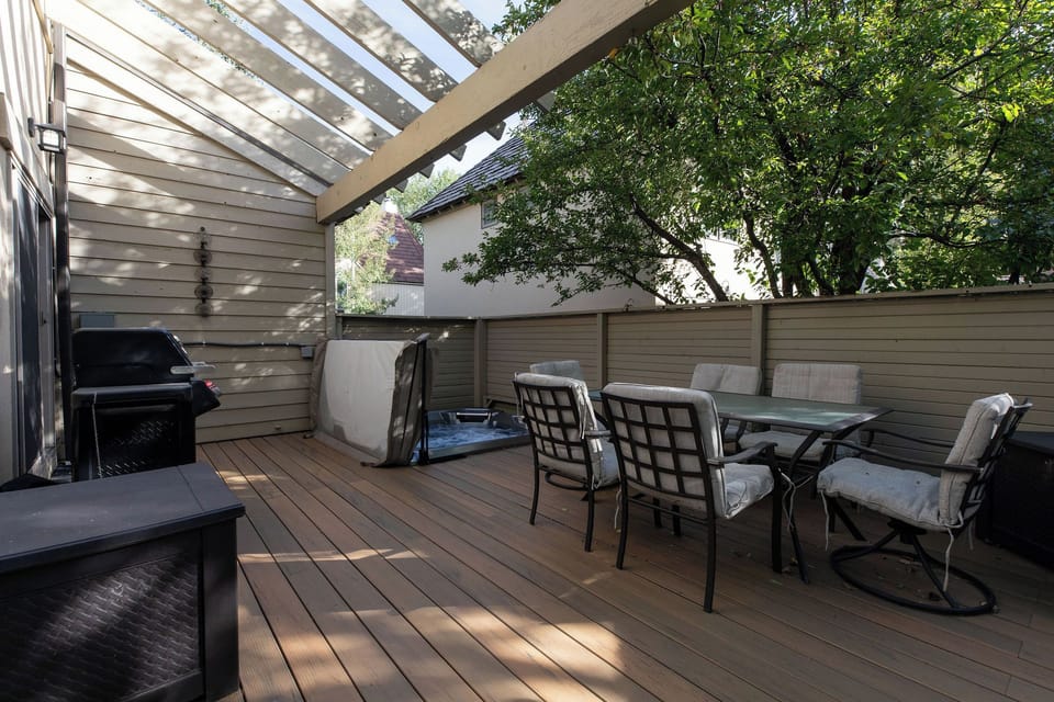 Deck with outdoor seating, grill and hot tub.