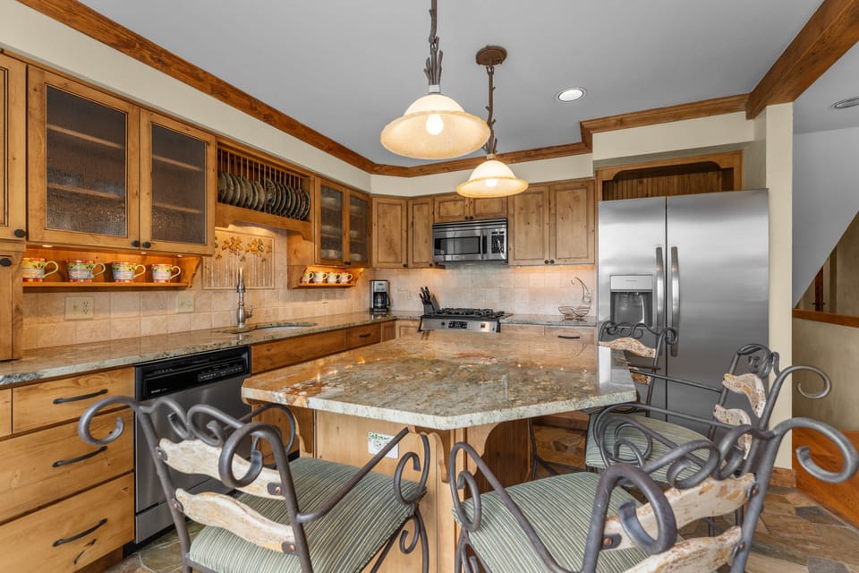 Gather around this inviting kitchen where warm wood tones and granite countertops create your perfect space for cooking and conversation. Modern appliances and thoughtful touches make meal prep a pleasure.