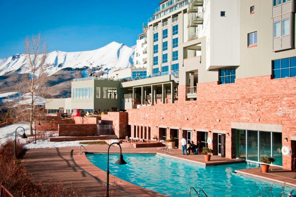 Building complex by a pool, snowy mountain in the background