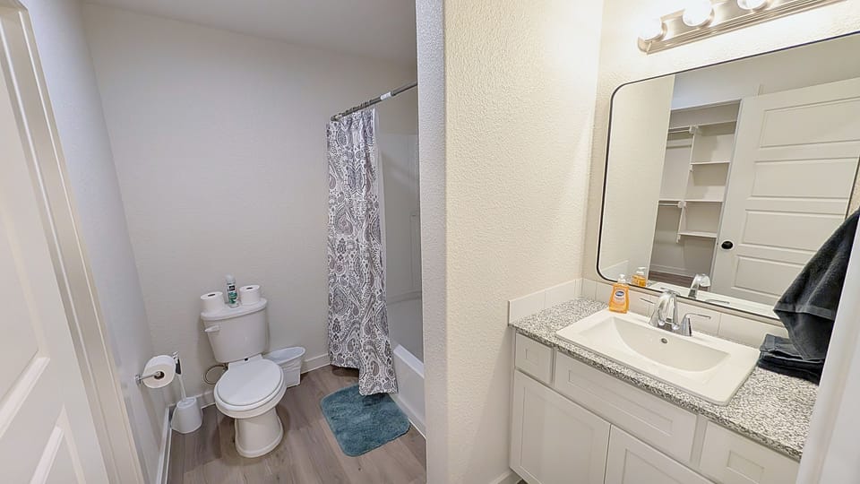 Bright full bath with granite vanity, great lighting, and tub-shower combo
