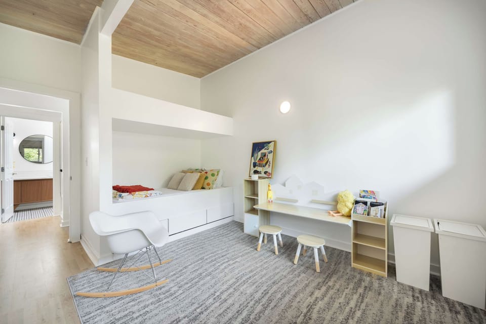 Kids’ room with a bed, play table, and storage.