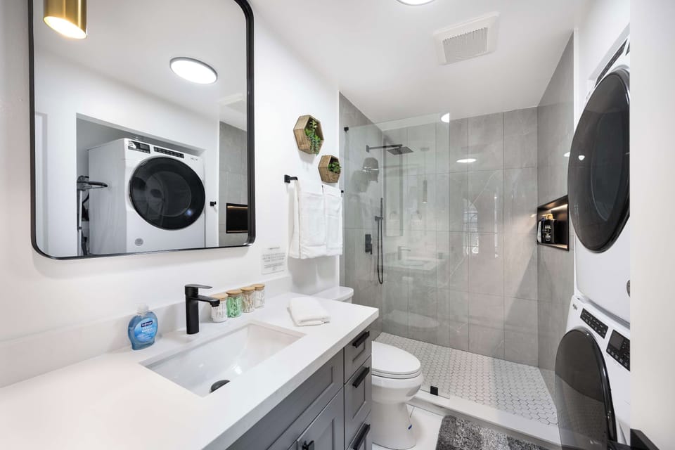 Unit 1 - Bathroom - 
Modern bathroom with a walk-in shower and in-unit washer/dryer, combining style and convenience.