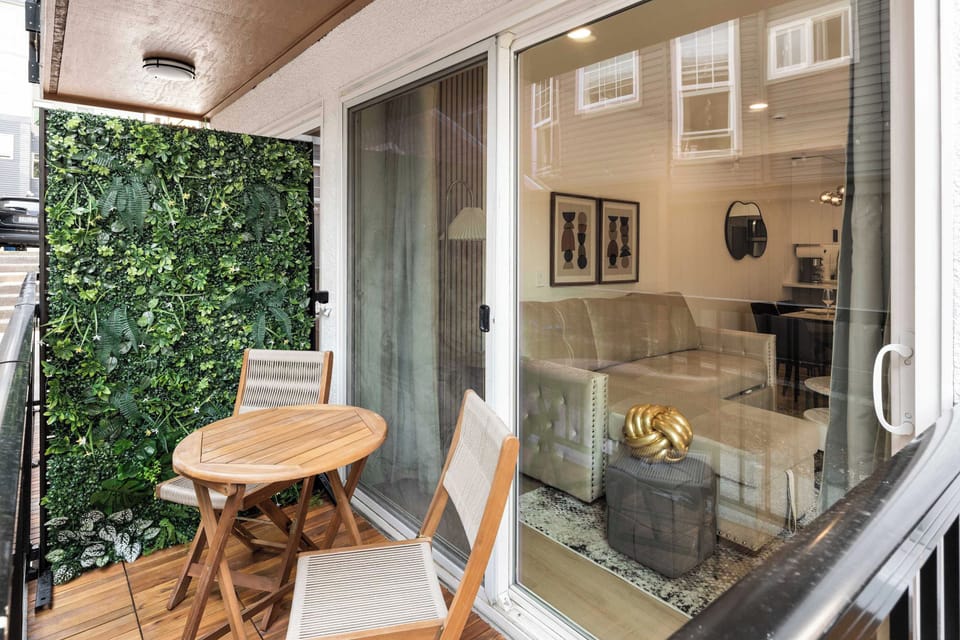 Unit 1 - Balcony - Cozy private balcony with a lush green wall, perfect for enjoying morning coffee or an evening drink in a serene outdoor setting.